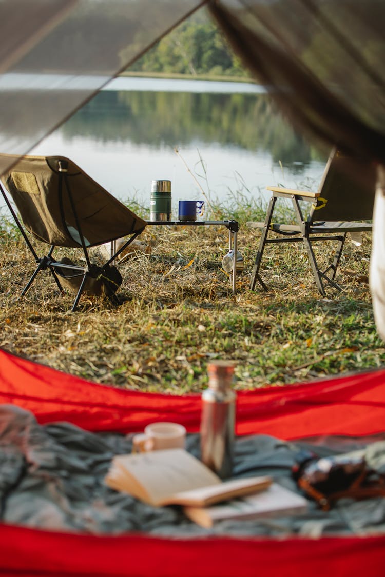 Camping Chairs And Tent Near Calm Lake