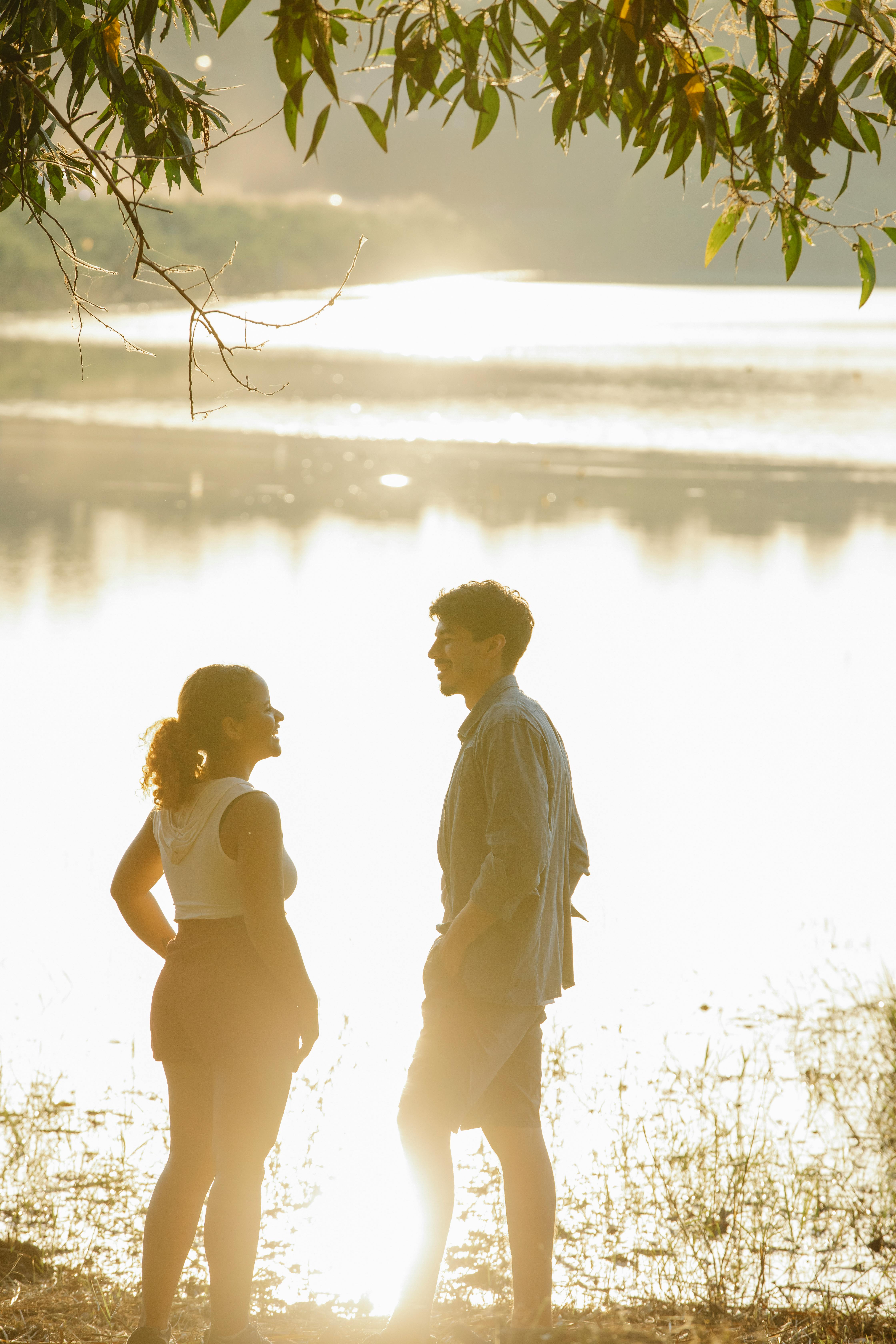 beloved young couple recreating at lakeside at sunset