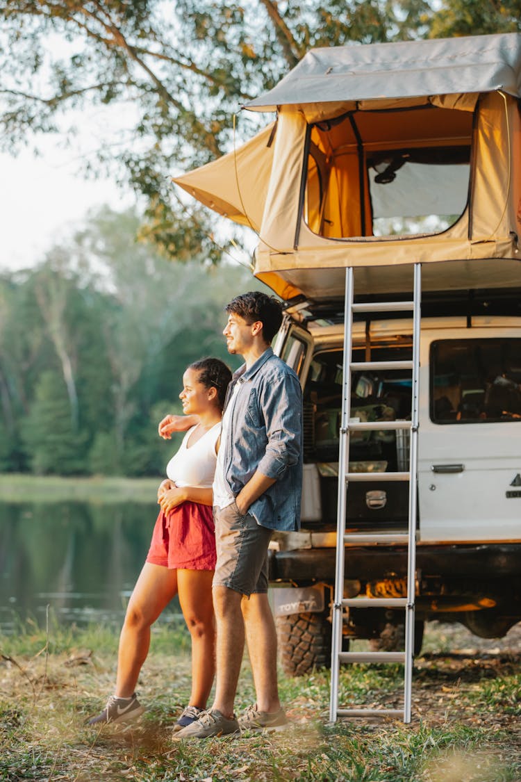 Romantic Young Multiracial Couple Cuddling And Enjoying Lake View During Road Trip