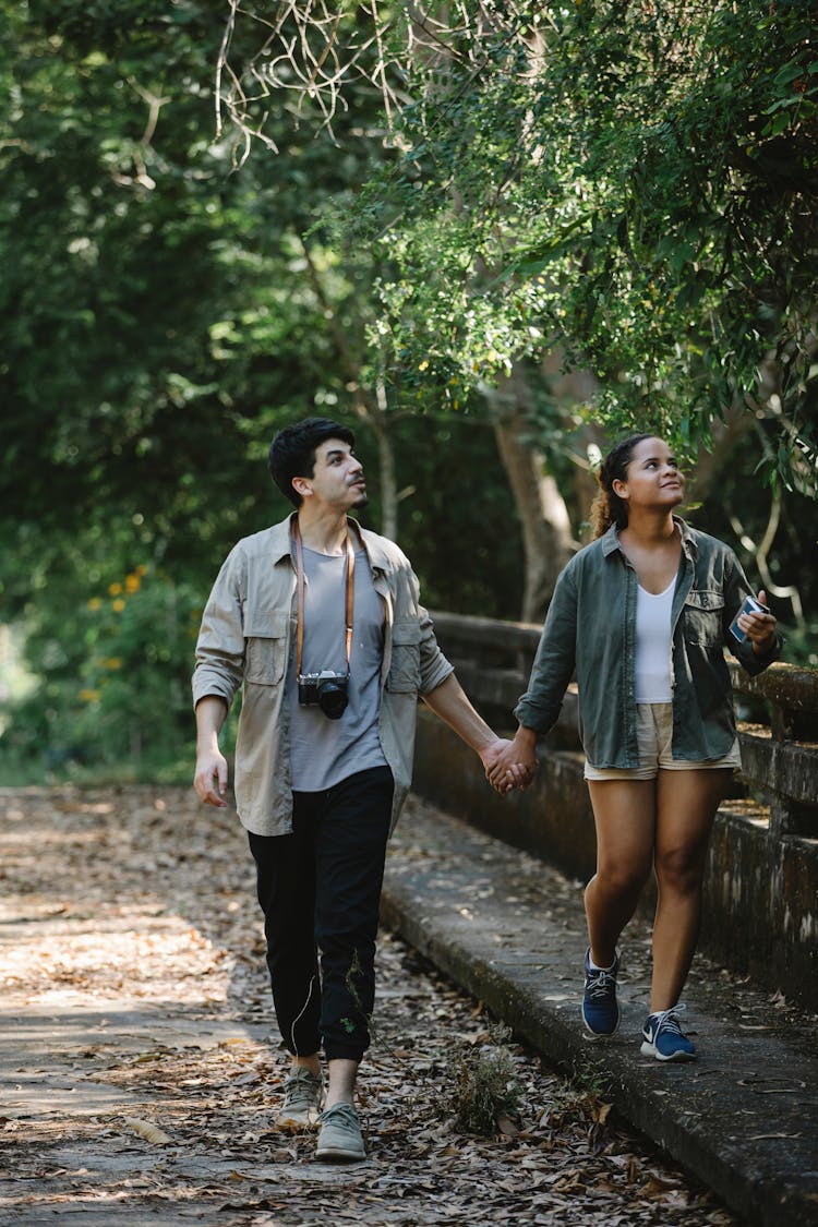 Happy Couple Of Travelers Walking In Park