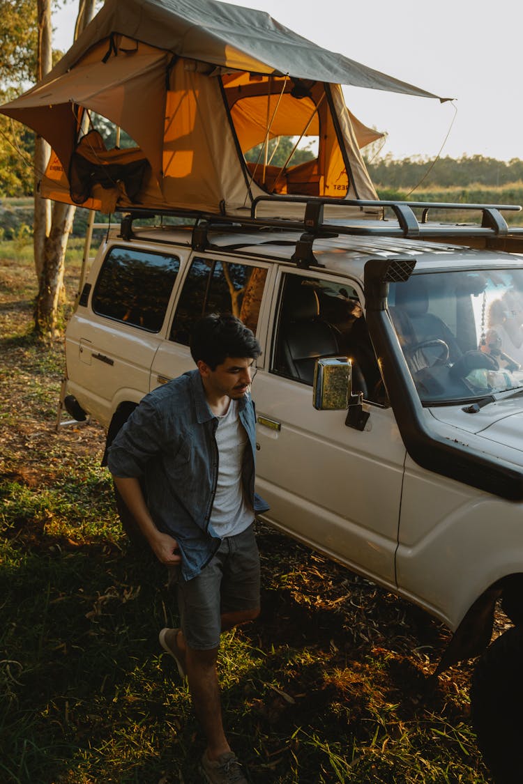 Man Near Car With Tent On Roof On Nature