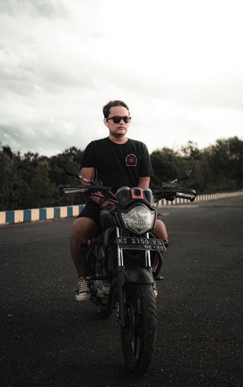 Free A Man in Sunglasses Sitting on a Motorcycle Stock Photo