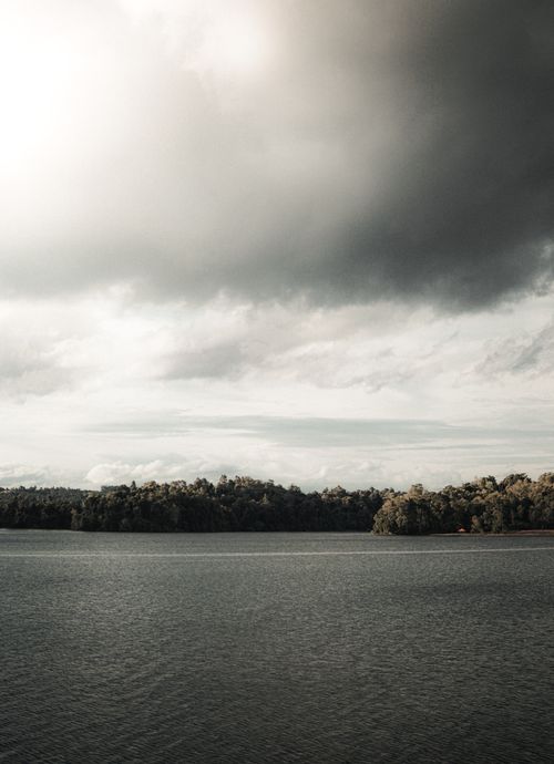 Free A tranquil lake with a dramatic cloud-filled sky, capturing nature's serene beauty. Stock Photo