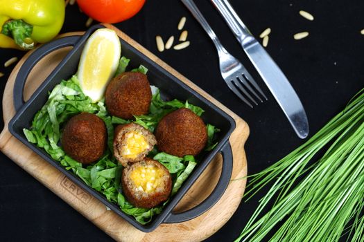 Delicious falafel served on a bed of fresh greens with lemon and vegetables.