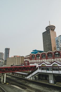 Contemporary Harbor Tower and overpass above railway tracks located in modern Vancouver center in daylight