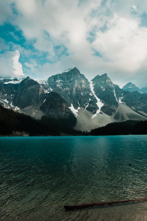 Peaceful stony mountains near calm water of lake