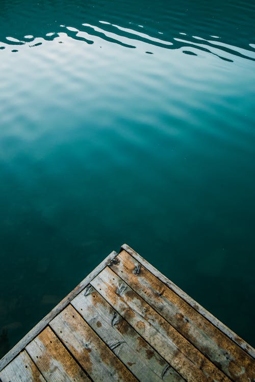 Wooden pier corner above calm rippling lake