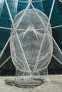 Art piece of wire mesh sculpture representing little girls head and located on base of modern glass tower in Calgary