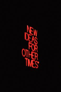 A vibrant red neon sign displaying the motivational message 'New Ideas for Other Times' on a solid black background.