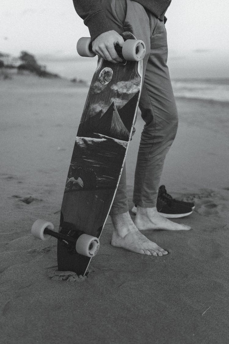 Crop Man With Longboard On Sandy Beach