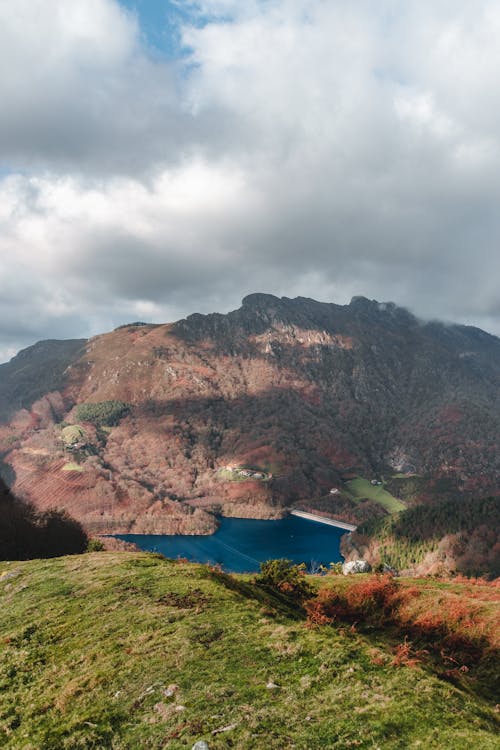 Blue lake in mountainous valley under cloudy sky