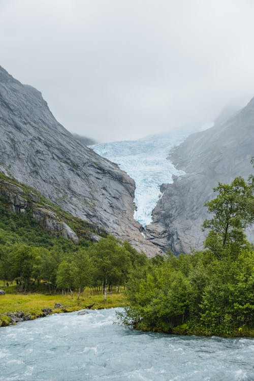 Free River flowing near trees and mountains Stock Photo