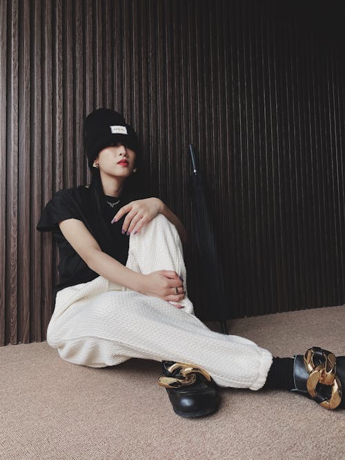 A Woman in a Stylish Outfit Sitting on the Floor