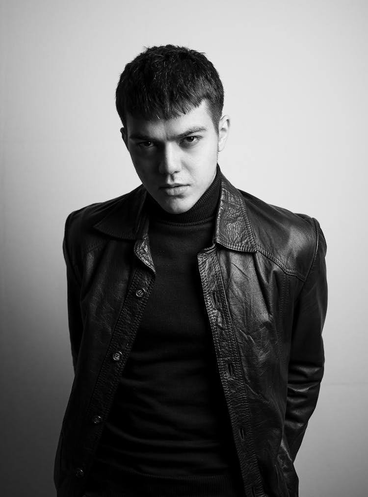 Serious Male In Leather Jacket Standing In Studio