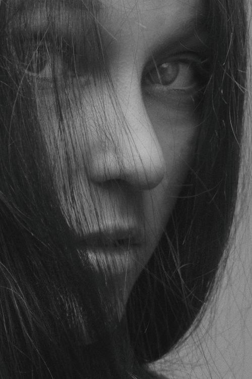 Free Close-up black and white portrait of a woman's face with hair. Stock Photo