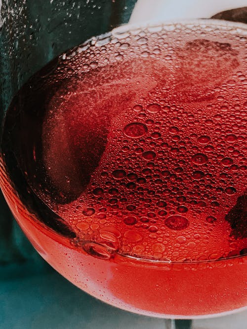 Glass of red sparkling wine served in table