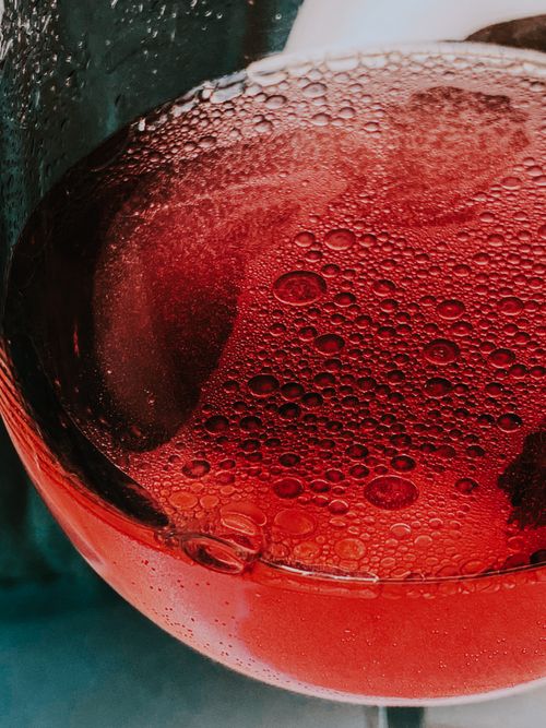Free From above of crystal glass of red fizzy refreshing drink placed on table Stock Photo