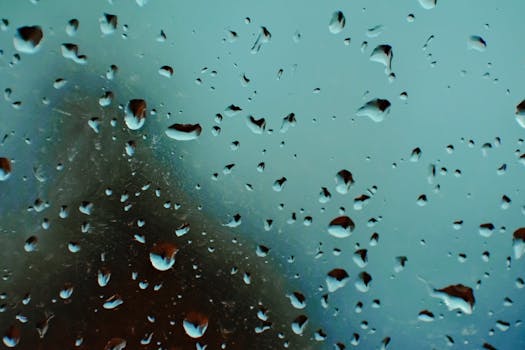 Closeup of abstract background of water drops on translucent misted glass window on rainy day
