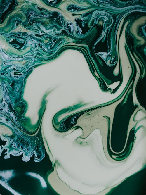 Abstract background of mixed liquid white and green dyes