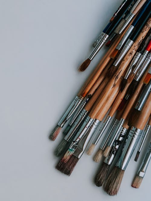 Set of various brushes placed on white desk in art studio