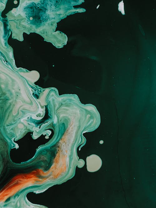 From above of background of liquid mixing colorful dyes forming abstract pattern in art studio