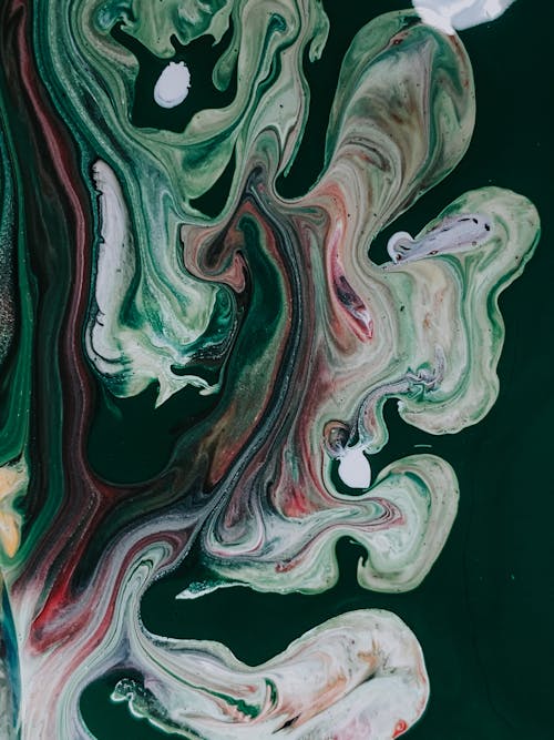 Colorful acrylic paints mixed in technique fluid art