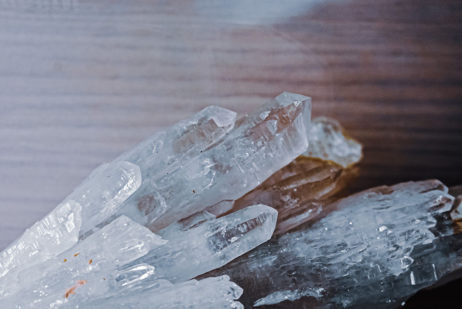 From above of clear natural quartz crystals placed on wooden table in daytime