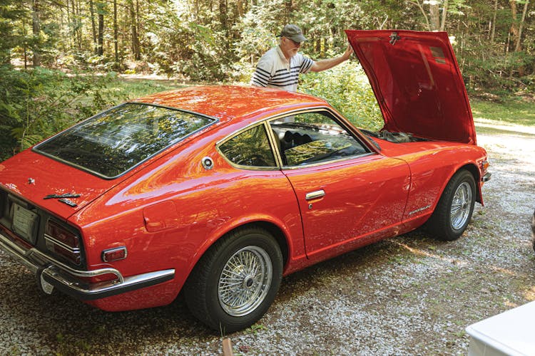 A Man Looking At A Datsun 240z 