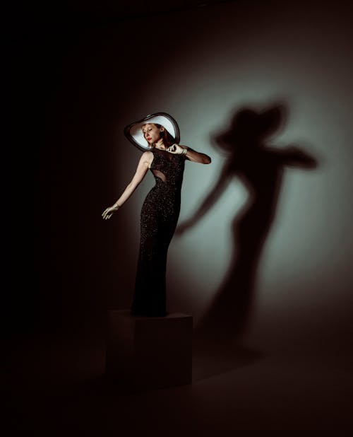 Женщина в черном платье стоя