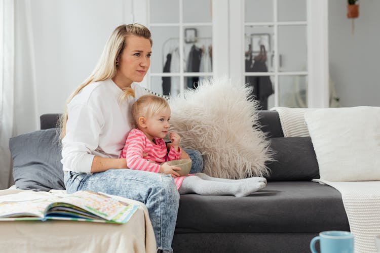 Woman Watching TV With Toddler Daughter