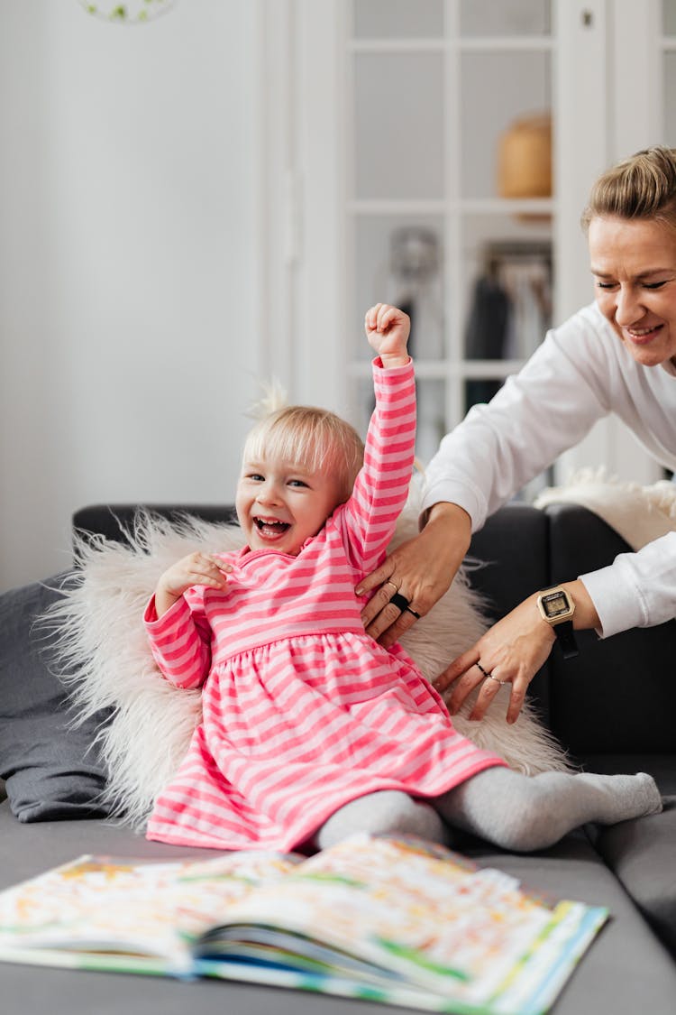 Little Girl Laughing Sitting On Couch