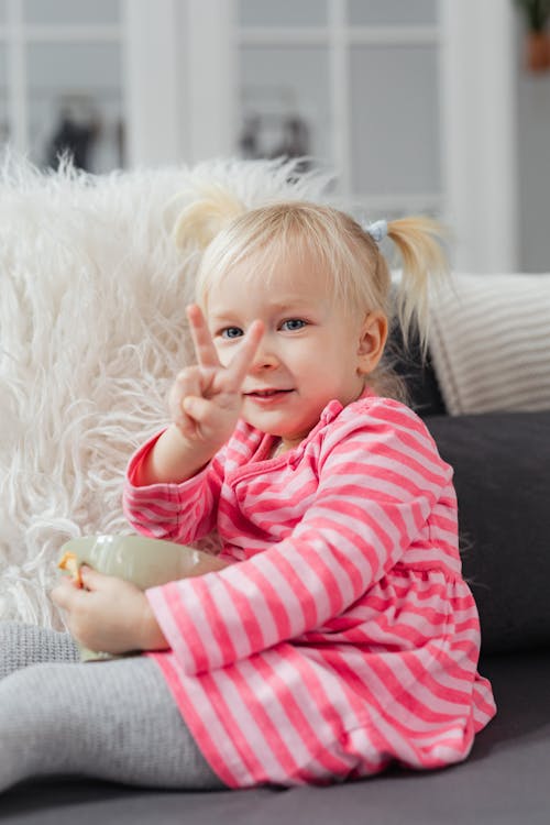 Little Blonde Girl Showing Peace Sign