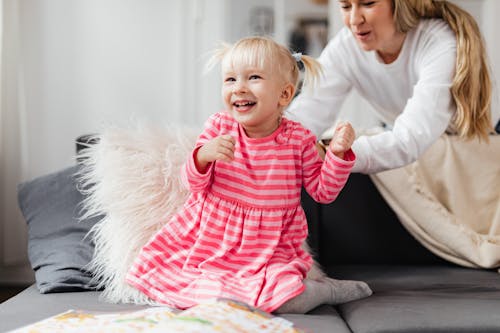 Free Smiling Daughter with Mother on Couch Stock Photo