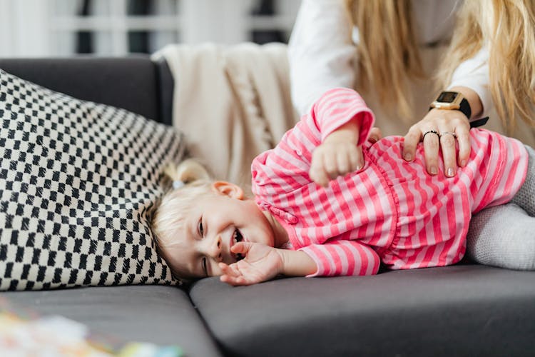 Mother Tickling Her Baby Daughter 