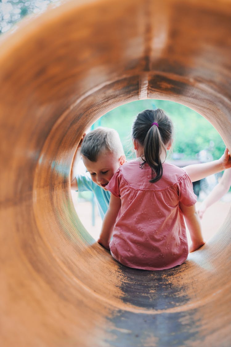 Children Playing Outside On A Playground In A Tube 