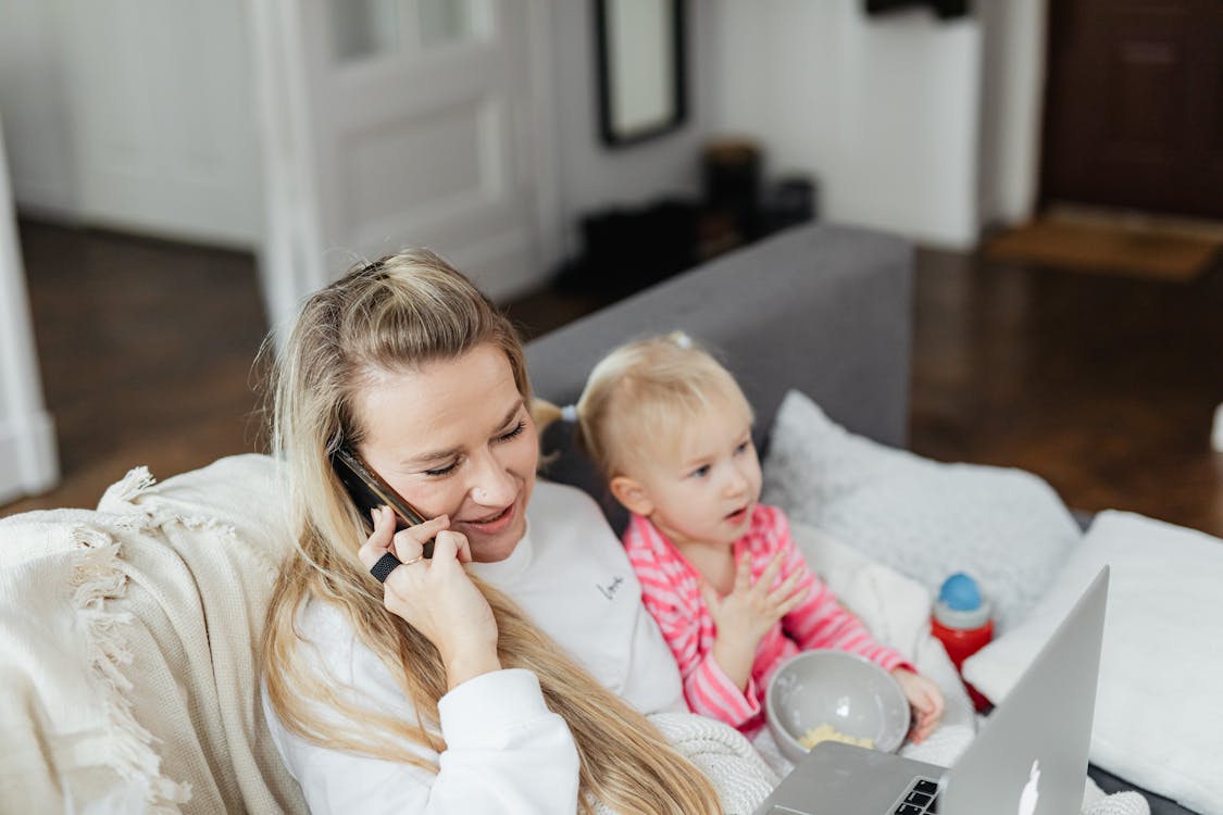 Free A Mother on a Phone Call While Caring for Her Daughter Stock Photo
