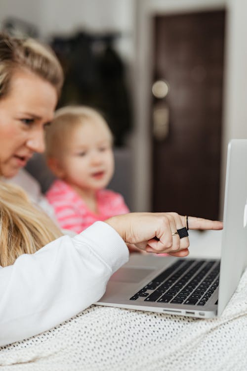 Free A Mom Besides Her Child Pointing to the Laptop Screen Stock Photo