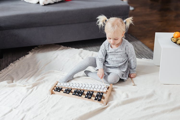 A Child Playing With A Xylophone