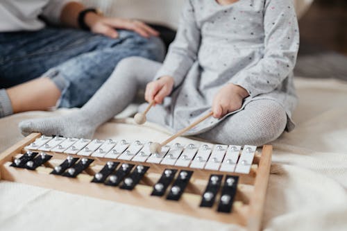 A Child Playing a Xylophone with Mallets