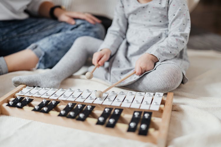 A Child Playing A Xylophone With Mallets