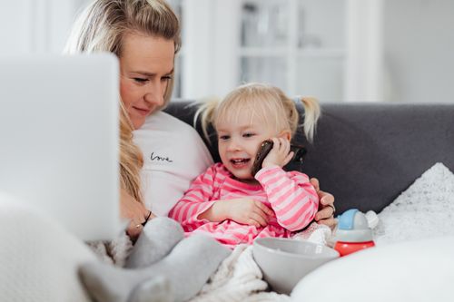 Free A mother and daughter sharing a playful moment indoors, engaging in a phone conversation. Stock Photo