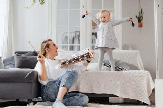 Mother and Daughter Having Fun and Playing Instruments 