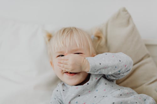 Free Baby in Gray and White Polka Dot Onesie Lying on White Textile Stock Photo