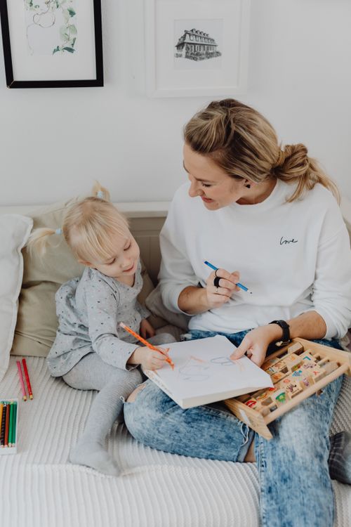 Free A mother and her daughter drawing together, enhancing creativity and bonding. Stock Photo