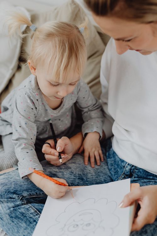 Free A mother and her toddler daughter drawing together, fostering creativity and family bonding. Stock Photo