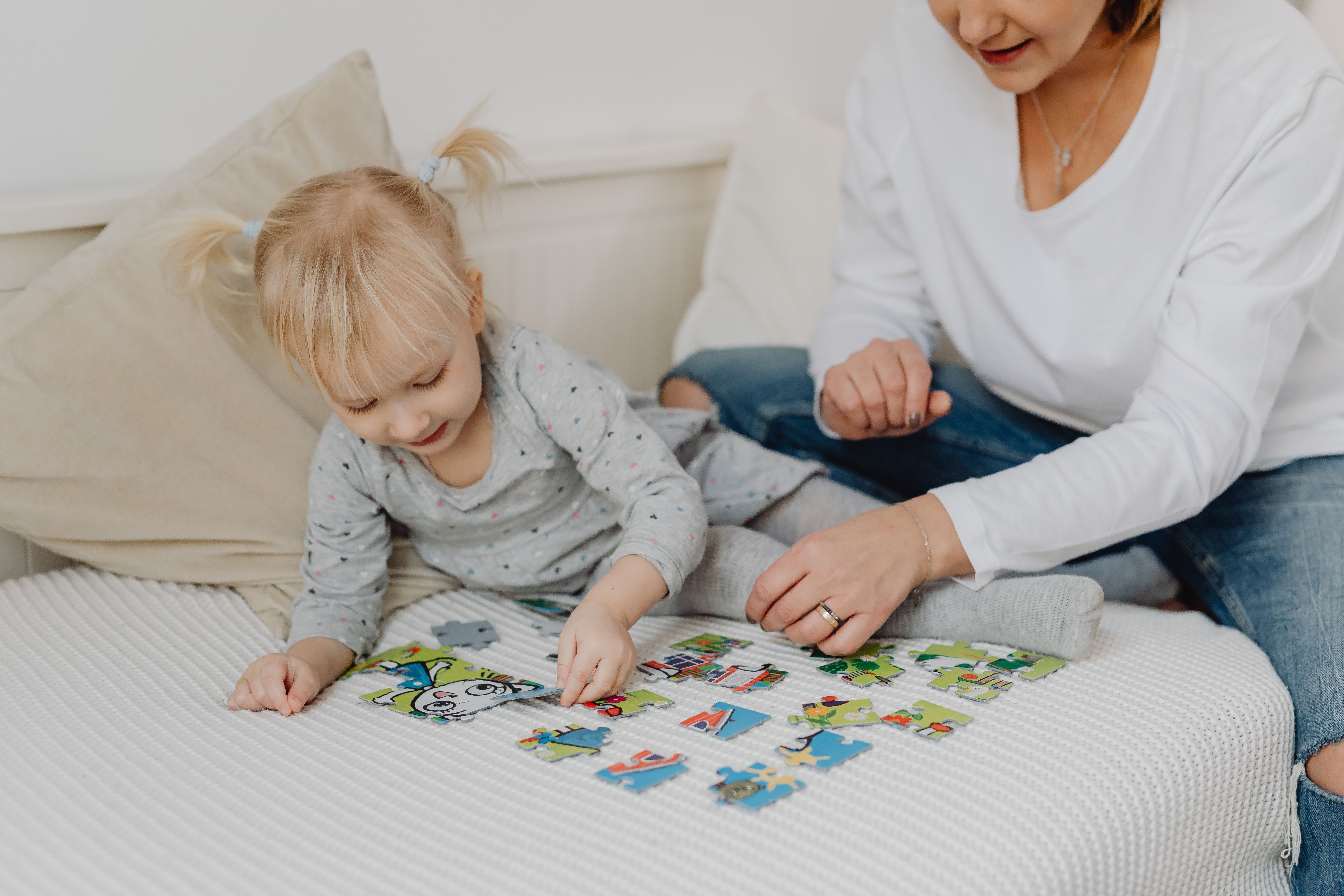 A mother and her young daughter bonding over a colorful puzzle indoors. - Photo by https://kaboompics.com/ on Pexels
