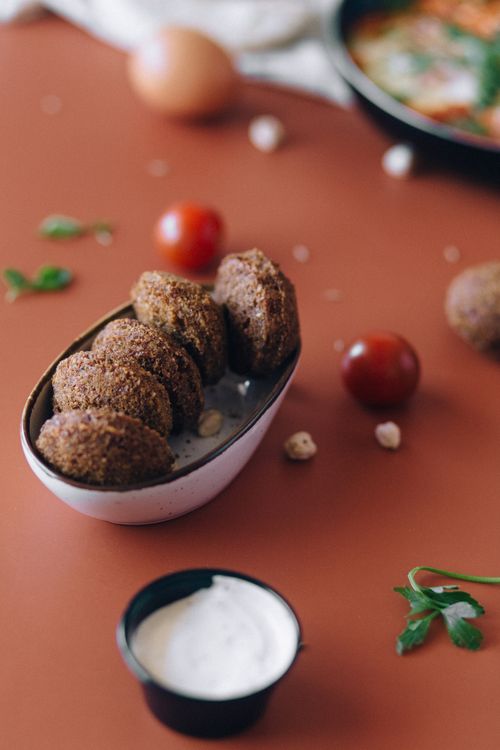 Free Freshly made falafel served with creamy dip and garnished with cherry tomatoes and herbs. Stock Photo