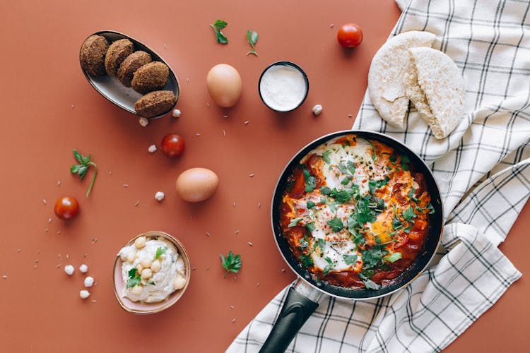 Food In A Pan And Eggs On An Orange Surface