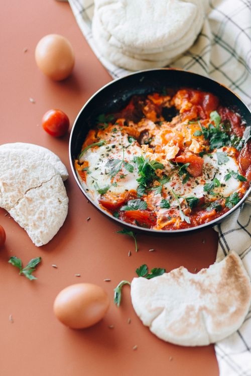 Free Savor the flavors of shakshuka, a delightful Middle Eastern dish with eggs, tomatoes, and herbs. Stock Photo
