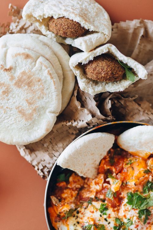 Free A flavorful Arabic dish featuring shakshuka, falafel, and fresh pita bread, perfect for breakfast or brunch. Stock Photo